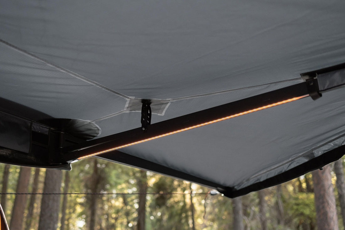 Taruca awning underside with an amber LED light bar glowing on the support arm