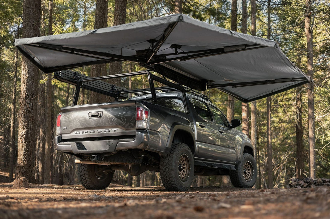 Taruca Rogue 270+ XC awning deployed over the side and rear of a Tacoma in a forest camp