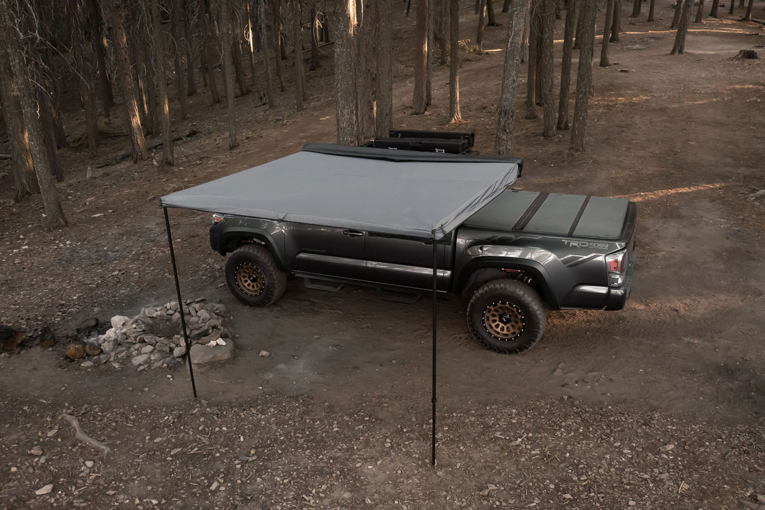 Taruca Rogue 8FT awning deployed with a support leg in a forest camp