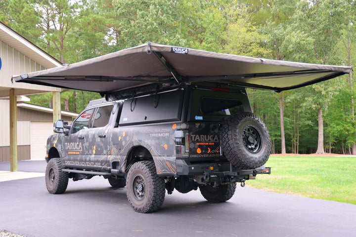 Taruca Rogue 270 S awning deployed and freestanding over the rear of a pickup, rear three-quarter view